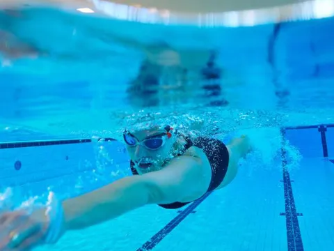 Schwimmmerin zieht im Pool ihre Bahnen