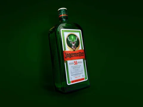 Flaska af Jägermeister með grænan bakgrunn