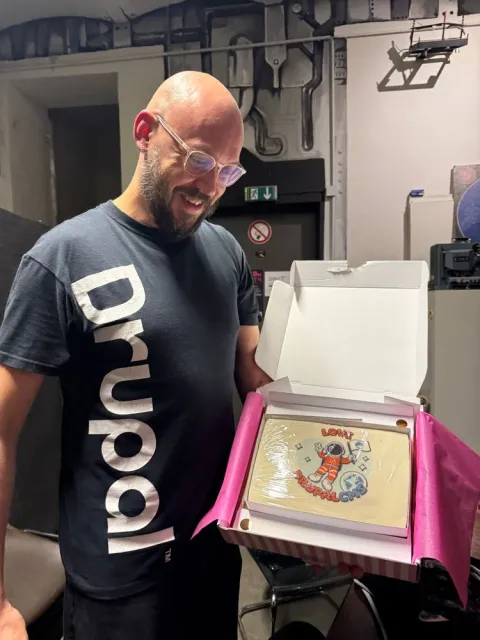 A man with a Drupal CMS cake