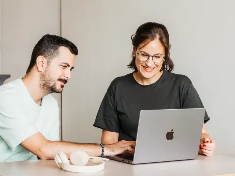 A man and a woman working together on a laptop
