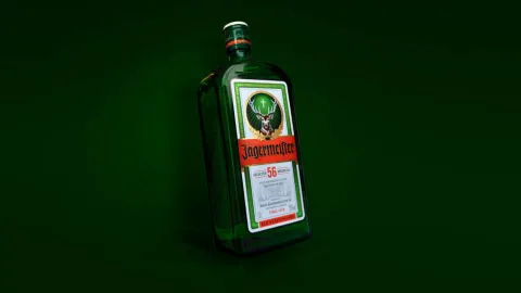 A bottle of Jägermeister on a green background